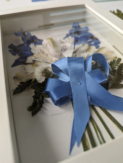 Bouquet of flowers with a blue ribbon in a box