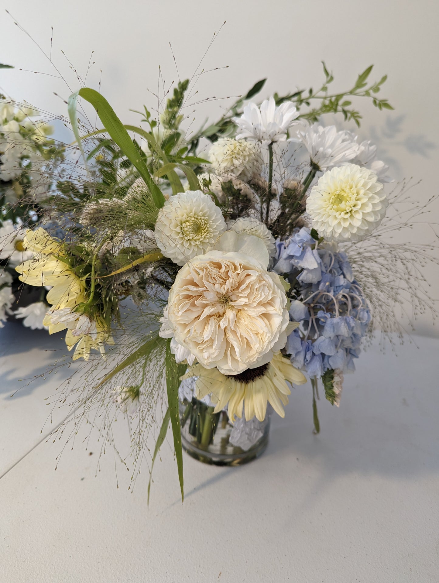 Bouquet of flowers with white, yellow, and blue colors on a light background