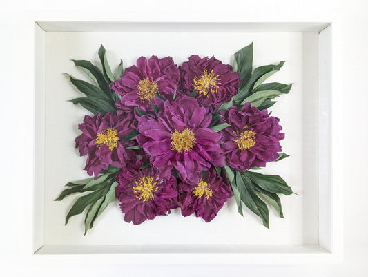 Framed artwork of purple flowers with green leaves on a white background